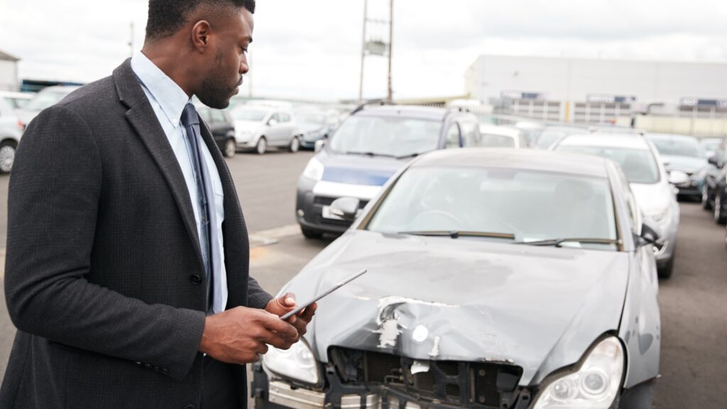 Adjuster from insurance inspecting wrecked car